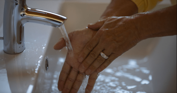 Washing hands in home sink with water hardness problems.