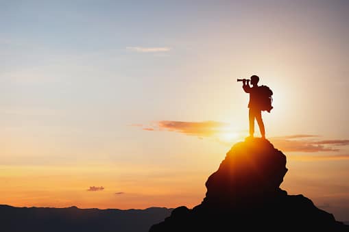 Water well repair near me search by a man standing in the sunset on a rock looking through a telescope.