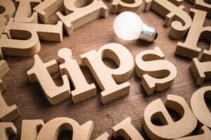 Tips Idea. Tips wood word in scattered wood letters with glowing light bulb. Tips For Private Water Well Owners - JB Water Well