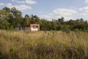 Old red mobile home. An old deserted mobile home on an overgrown field. Old Wells on Your Property - JB Water Well