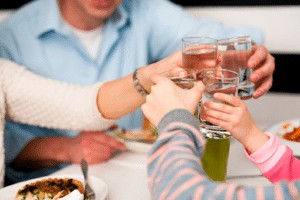 Family toasting water glasses in celebration of upgrade to water well from JB Water Well.